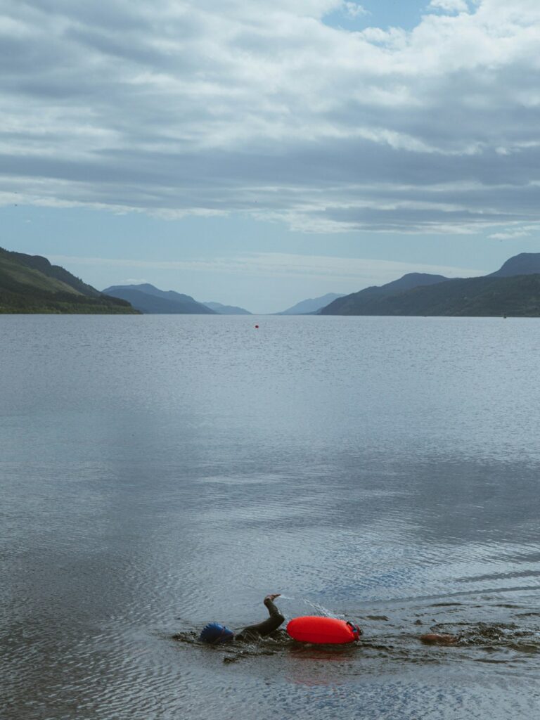 Red buoy on a calm loch with distant mountains