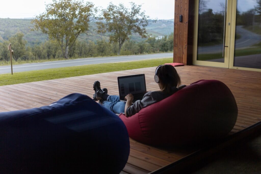 a person sitting on a bean bag chair using a laptop